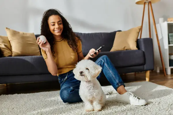 Woman sitting on floor, engrossed in cellphone. — Stock Photo