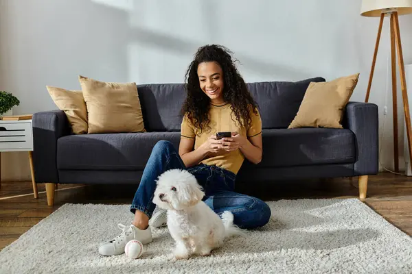 Woman sitting beside her fluffy Bichon Frise on the floor. — Stock Photo