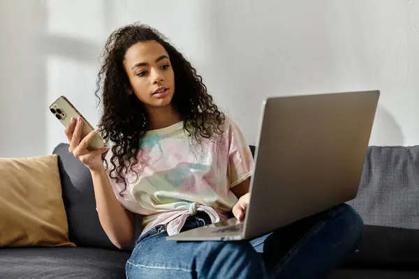 Woman on couch, multitasking with cell phone and laptop. — Stock Photo
