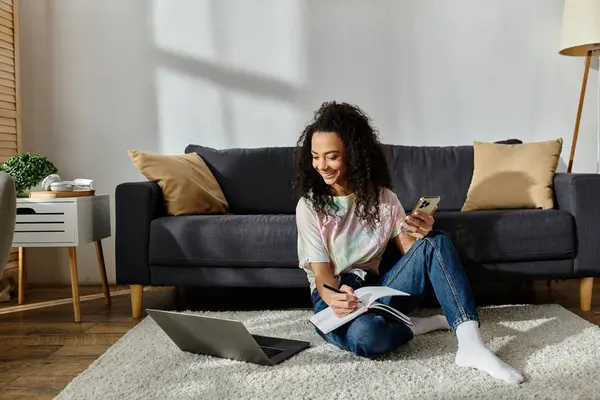 Woman sitting on floor, engrossed in cell phone. — Stock Photo