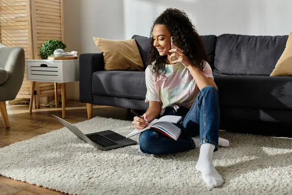 Eine junge Frau sitzt auf dem Boden, vertieft in ihren Laptop. — Stockfoto