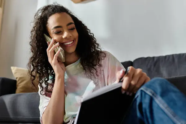 Woman sitting on couch speaks on phone. — Stock Photo
