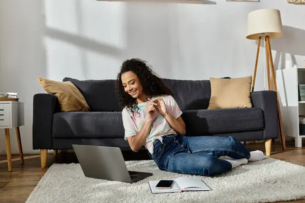 A woman seated on the floor, absorbed in laptop use. — Stock Photo