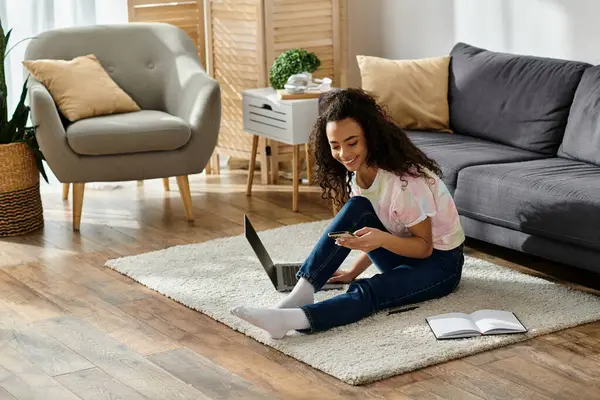 A young woman engrossed, sitting on floor with laptop. — Stock Photo