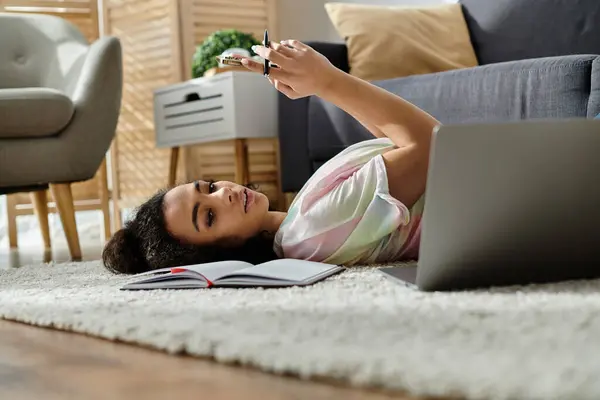 A woman relaxes on the floor, engrossed in her laptop. — Stock Photo