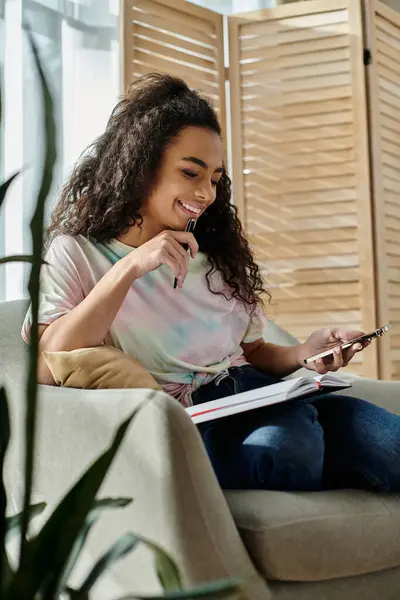 Woman on couch engrossed in cell phone. — Stock Photo