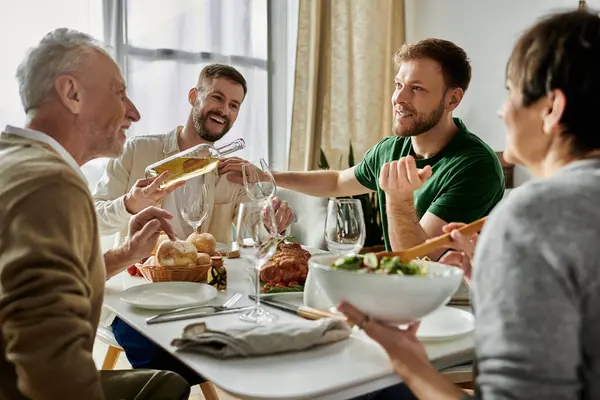 Um casal gay desfruta de uma refeição com sua família em casa. — Fotografia de Stock