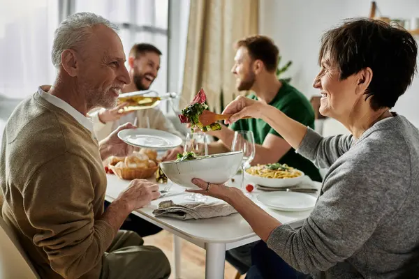A gay couple enjoys dinner with parents, showcasing a heartwarming moment of family acceptance. — Stock Photo