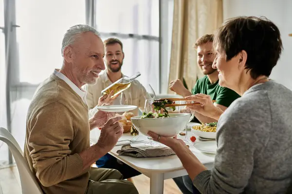 Una coppia gay si gode la cena con i genitori a casa. — Foto stock