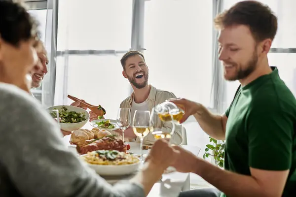 A gay couple shares a toast with their family at a home dinner. — Stock Photo