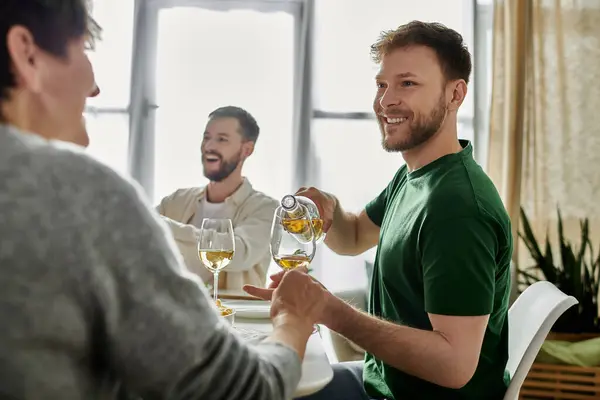 A gay couple shares wine with parents during a meal at home. — Stock Photo