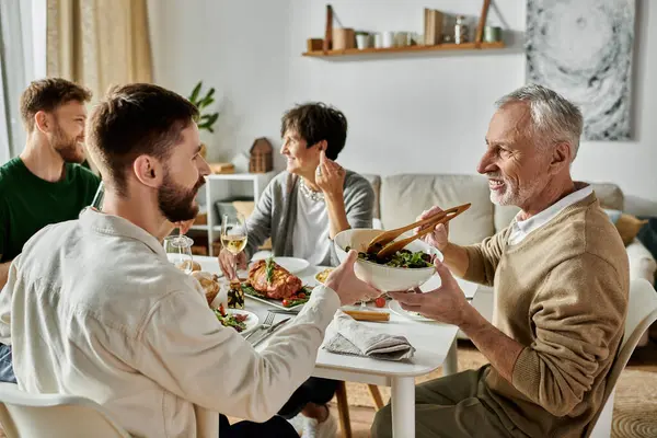 A gay couple enjoys a meal with their family at home. — Stock Photo