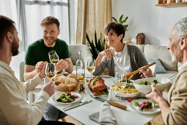 A gay couple shares a meal with parents in a cozy home setting. — стоковое фото