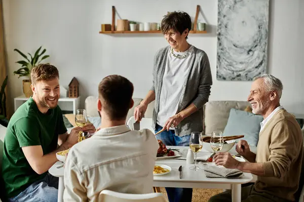 A gay couple enjoys a dinner with parents at home. — стоковое фото