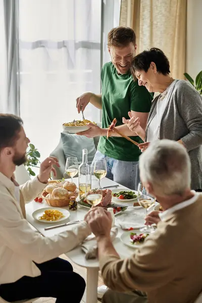 A gay couple enjoys a meal with parents at home. — Stock Photo