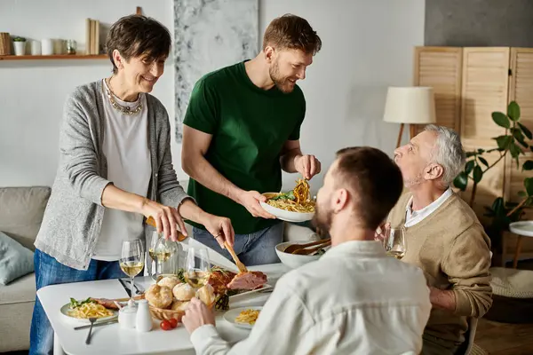 A gay couple enjoys a meal with parents at home. — стоковое фото