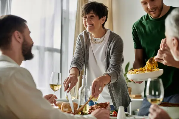 A gay couple enjoys a home-cooked meal with their family, filled with smiles and conversation. — Stock Photo