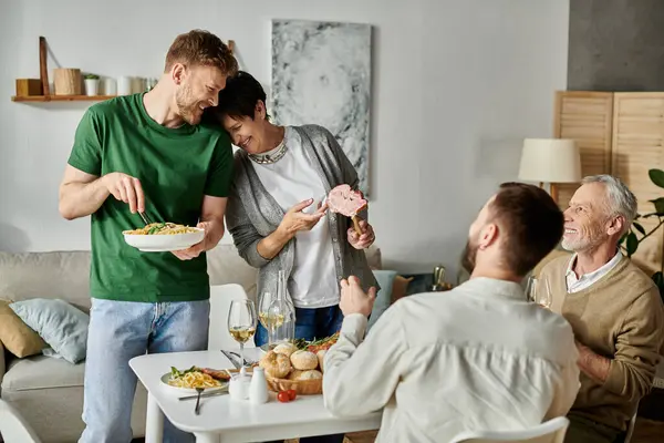 Una coppia gay gode di una cena con i genitori a casa. — Foto stock