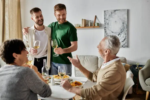 A gay couple toasts with parents during a dinner at home. — Stock Photo