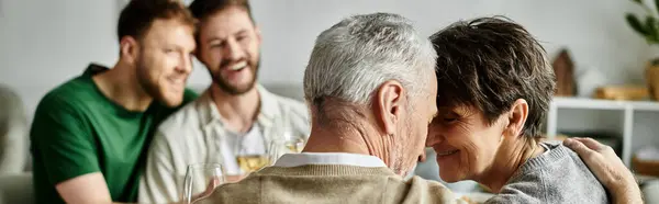 A gay couple shares a tender moment with parents in a heartwarming scene at home. — Stock Photo