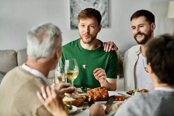 A gay couple introduces their partners to their family over a home-cooked meal. — стоковое фото