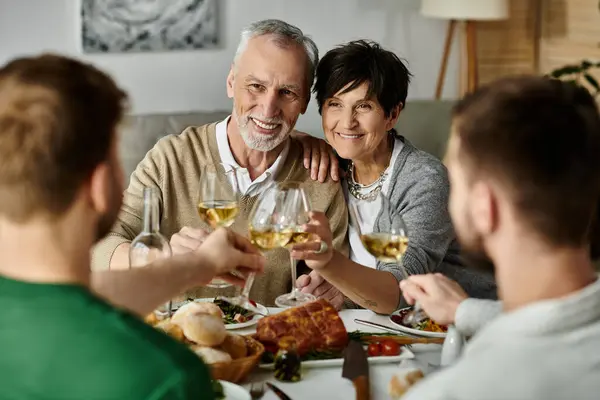 Una coppia gay gode di un pasto con i genitori a casa. — Foto stock