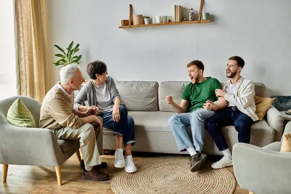 A gay couple sits on a couch and talks with parents in a living room. — Stock Photo