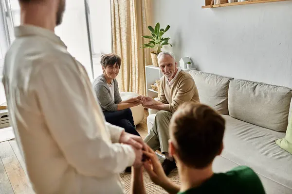 Un couple gay présente son partenaire aux parents dans un cadre familial chaleureux. — Photo de stock