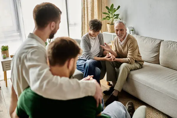 Una pareja gay presenta a sus parejas a sus padres en una escena conmovedora. - foto de stock