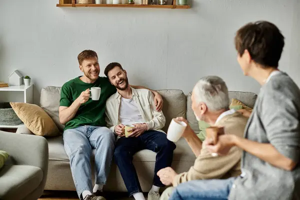 A gay couple enjoys coffee with parents in their living room. — стоковое фото