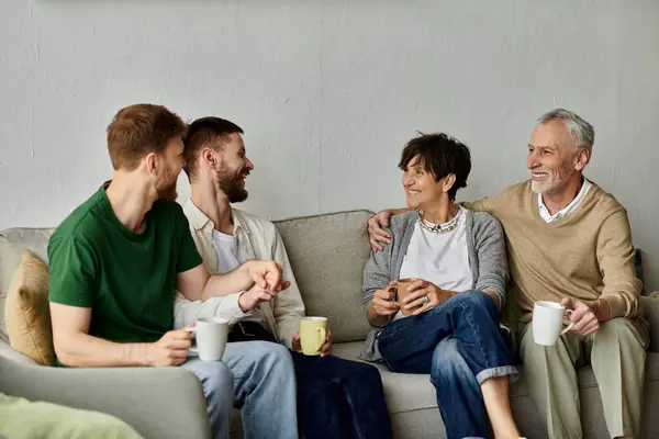 A gay couple enjoys a cozy conversation with parents at home. — Stock Photo