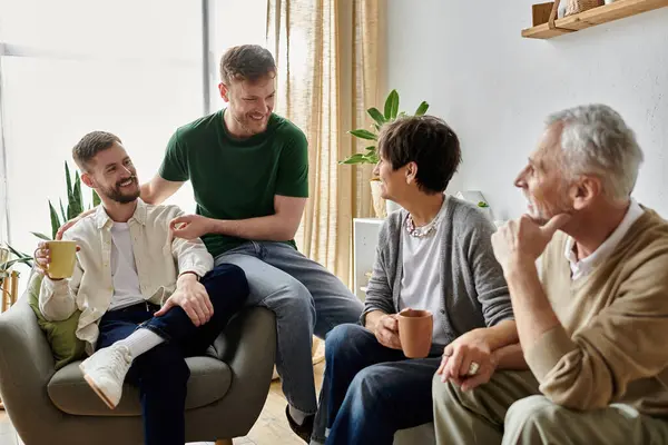 A gay couple shares a heartwarming moment with parents in a cozy living room setting. — Stock Photo