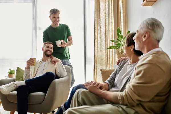 A gay couple enjoys a casual, heartwarming meeting with parents at home. — Stock Photo