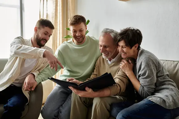 Un couple gay est assis avec des parents, regardant un album photo ensemble. — Photo de stock