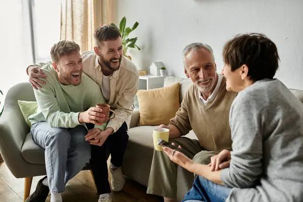 A gay couple smiles and laughs with parents in a living room. — Stock Photo