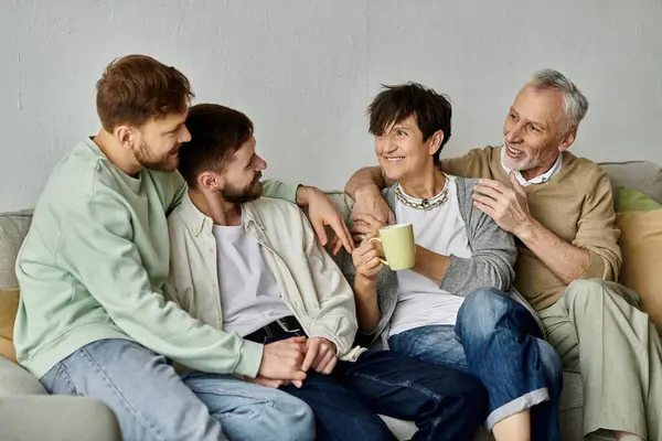 Um casal gay se senta com os pais em um sofá em casa, compartilhando um momento acolhedor e íntimo. — Fotografia de Stock