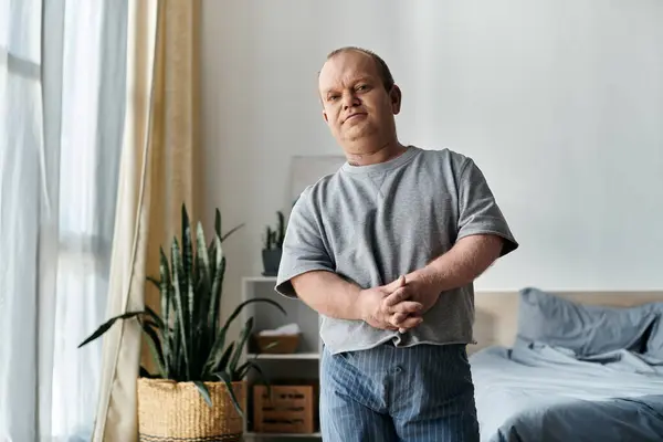 Чоловік з інклюзивністю стоїть у своєму будинку, дивлячись в бік камери. — стокове фото
