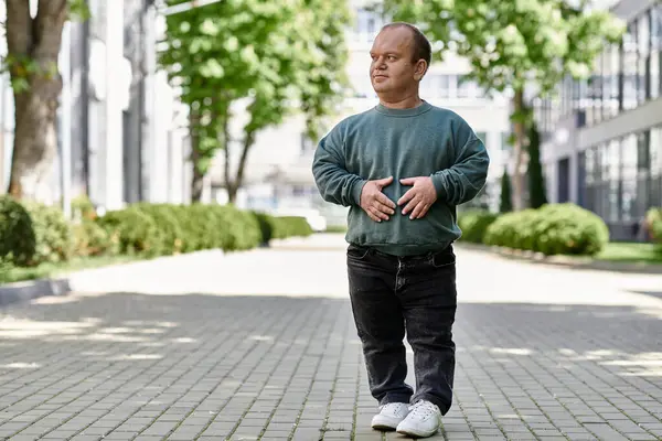 A man with inclusivity walks down a city street, showcasing his strength and self-assurance. — Stock Photo