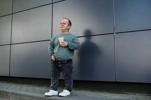 Draußen auf einer Straße in der Stadt steht ein Mann mit einer Tasse Kaffee. — Stockfoto