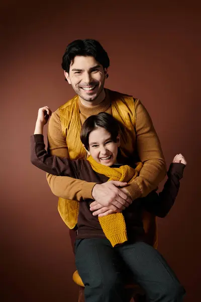 A father and son share a warm embrace, laughing together in a studio setting. — Stock Photo
