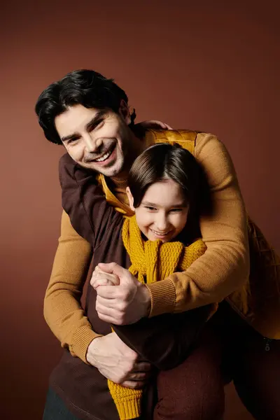 A father and his son share a warm embrace, laughing together in a studio setting. — Stock Photo