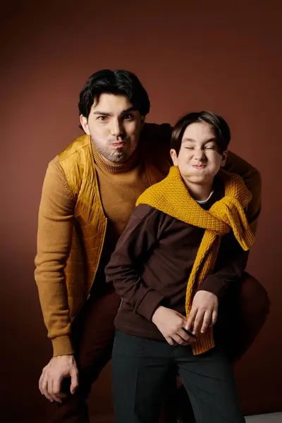 A father and his son pose together, both making silly faces. — Stock Photo