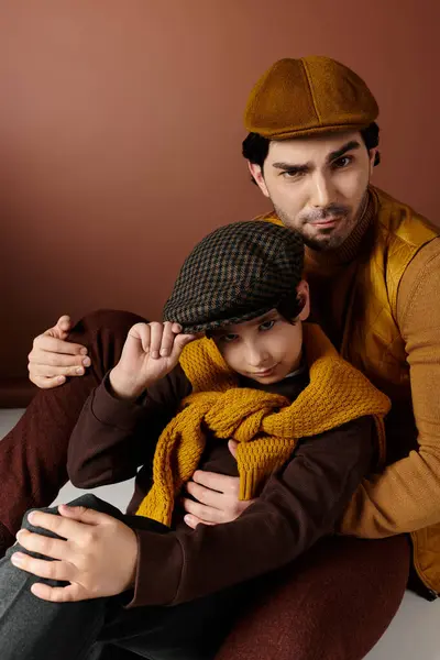 A father and son share a warm moment, the father holding his son close while the son plays with his cap. — Stock Photo