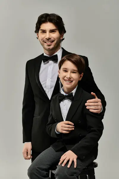 A father and son in formal attire, smiling and sharing a moment together. — Stock Photo