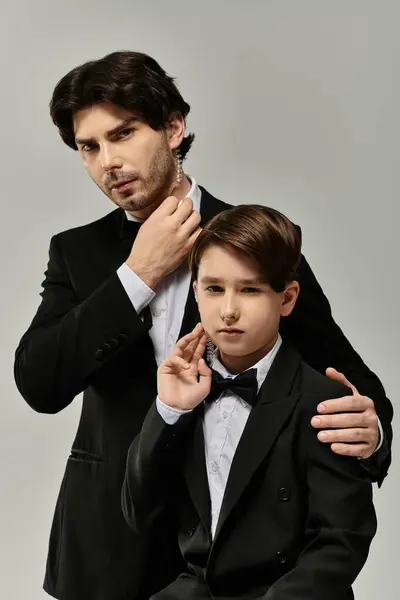 Vater und Sohn, beide in formeller Kleidung, stehen Seite an Seite und zeigen ein Band der Liebe und des Stolzes. — Stockfoto