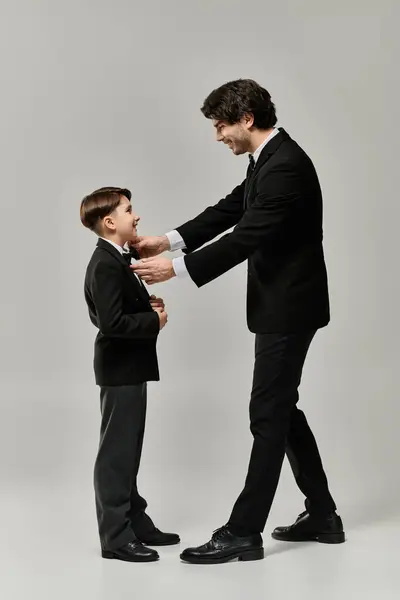 A father helps his son put on his first suit. — Stock Photo