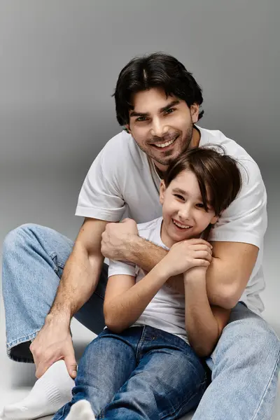 A father and son share a loving embrace, both smiling brightly. — Stock Photo