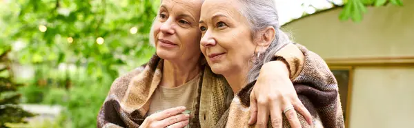Two middle-aged women in a loving embrace, enjoying a camping trip in the lush forest. — Stock Photo