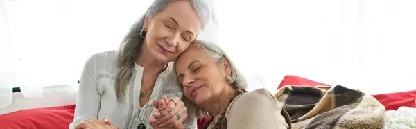 A middle-aged lesbian couple cuddles inside their camper van, enjoying a peaceful moment on their road trip. — Stock Photo