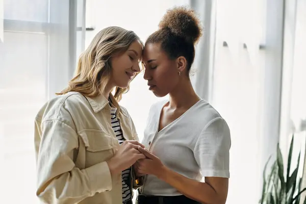 A diverse lesbian couple shares a tender moment at home. — Stock Photo